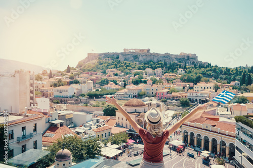 Enjoying vacation in Greece. Young traveling woman with national greek flag enjoying view of Athens city and Acropolis.