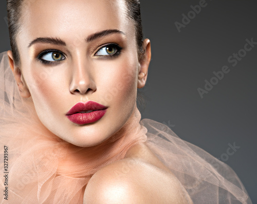 Beautiful woman with  red lips wearing beige scarf photo