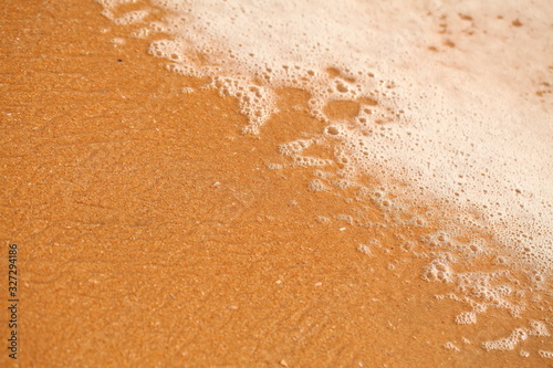 white foam on sandy tropical ocean beach