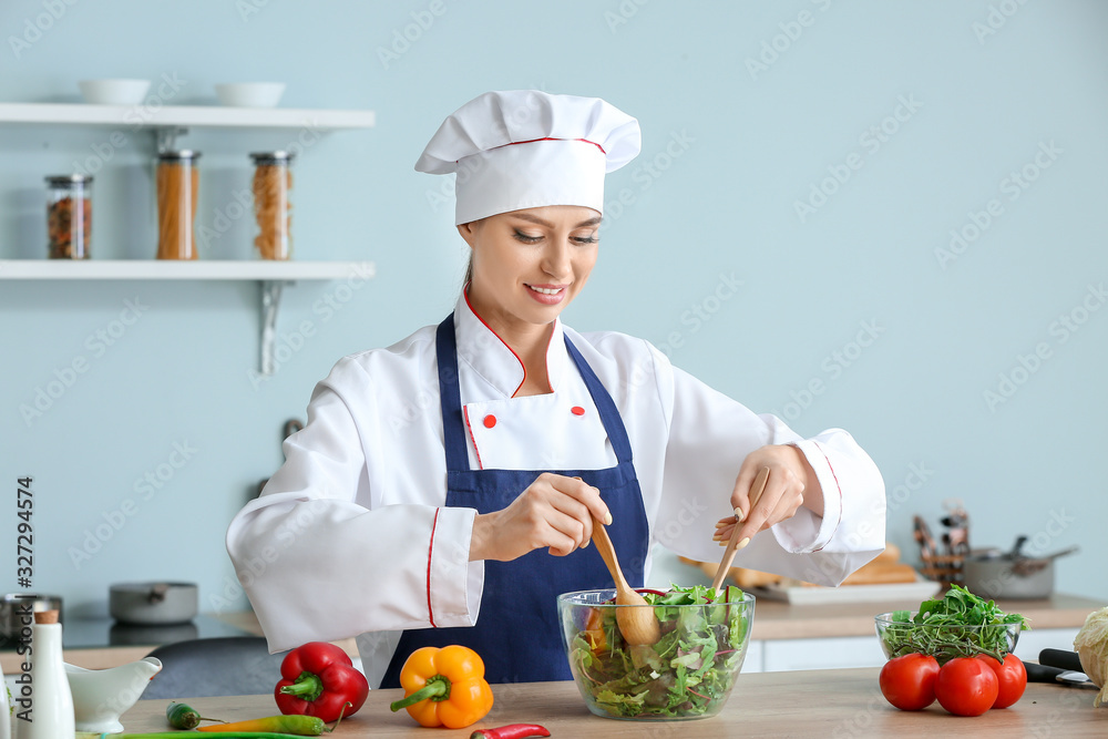 Female chef making fresh salad in kitchen Female chef making fresh salad in kitchen