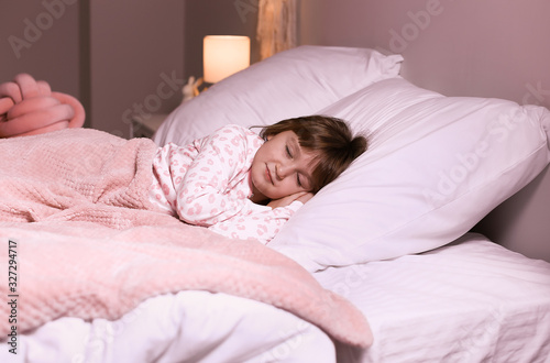 Cute little girl sleeping in bed at night