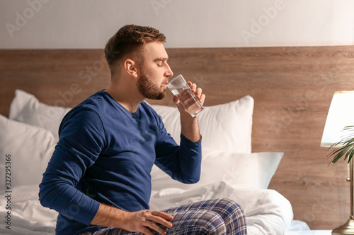 Young man drinking water in...