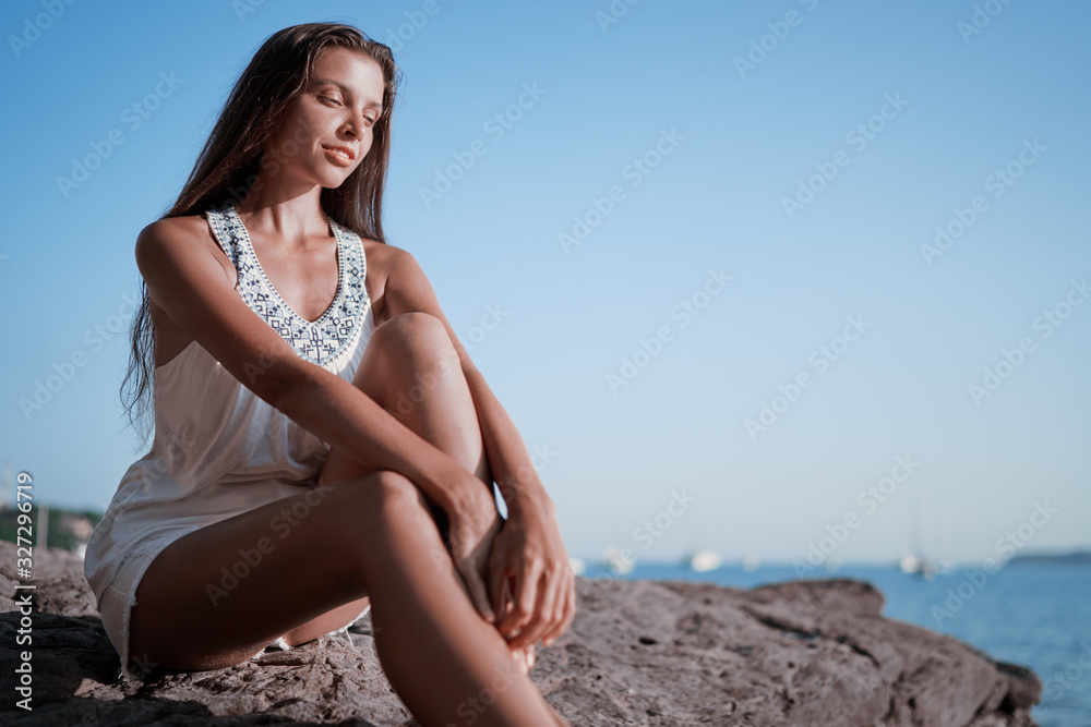 Outdoor portrait of young beautiful woman with long hair on the sea beach. Outdoor portrait of young beautiful woman with long hair on the sea beach.
