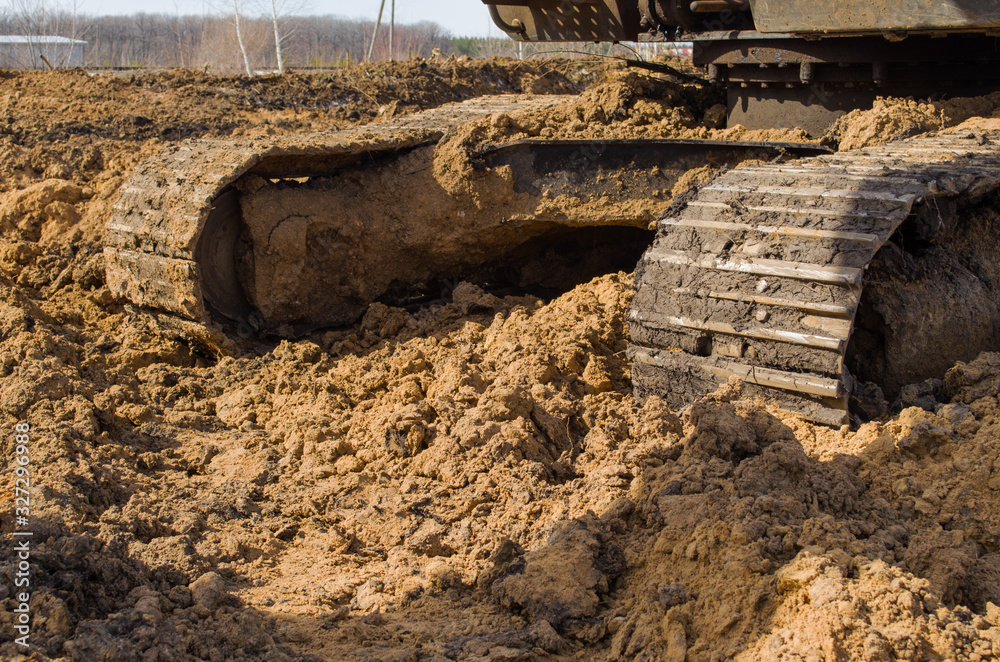 the tracks of a bulldozer, covered in mud, close-up the tracks of a bulldozer, covered in mud, close-up