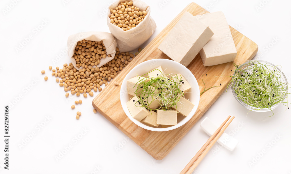Diced soy cheese Tofu, Microgreens on wooden board with chopsticks Diced soy cheese Tofu, Microgreens on wooden board with chopsticks