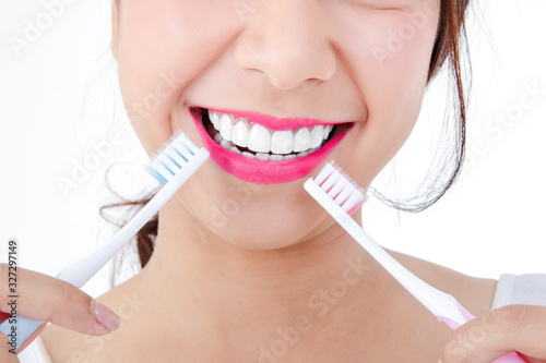 Beautiful smiling woman, clean white teeth, pink lips, hold a toothbrush. Oral care concept. White background