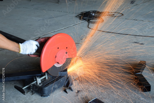  Man uses a metal cutting tool to create a red spark.
