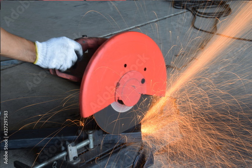  Man uses a metal cutting tool to create a red spark.