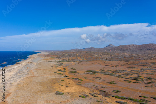 Aerial view of coast of Curaçao in the Caribbean Sea with turquoise water, cliff, beach and beautiful coral reef over Watamula