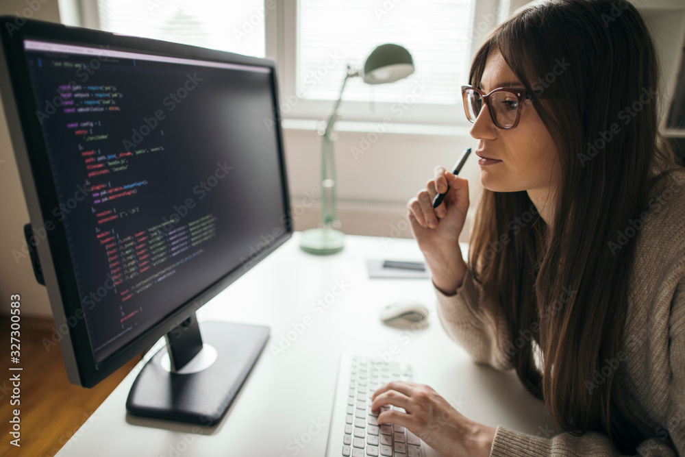 Young woman programming at her home office Young woman programming at her home office