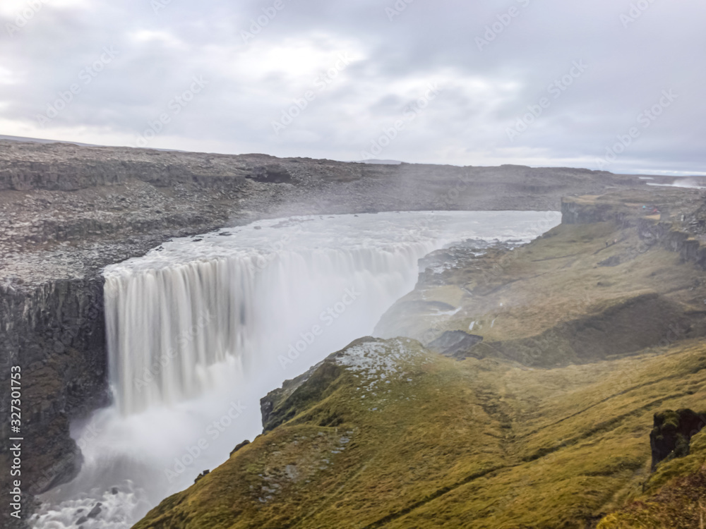 Dettifoss waterfall in Iceland long exposure of water falling over the edge creating massive clouds of spray