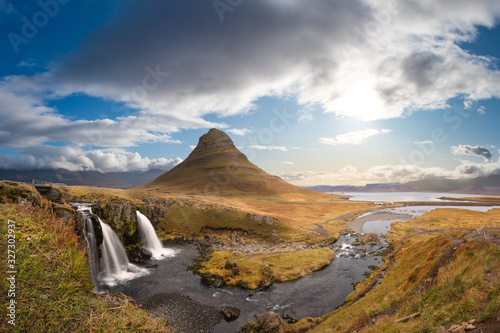 Kirkjufell in Iceland Kirkjufellsfoss waterfall and famous mountain under beautiful blue sky © MXW Photo