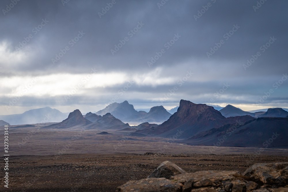 Obraz premium Langjokull Glacier epic mountain formations under dark clouds with small gaps of sun