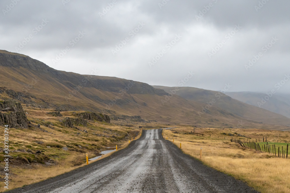 Roadtrip in Iceland gravel road along icelandic coast during rainy grey weather