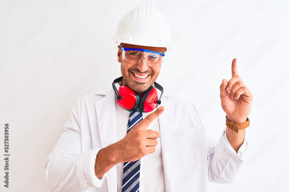 Young chemist man wearing security helmet and headphones over isolated background smiling and looking at the camera pointing with two hands and fingers to the side. Young chemist man wearing security helmet and headphones over isolated background smiling and looking at the camera pointing with two hands and fingers to the side.