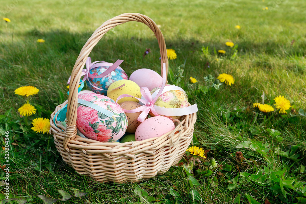 Wicker basket with Easter eggs in the garden.