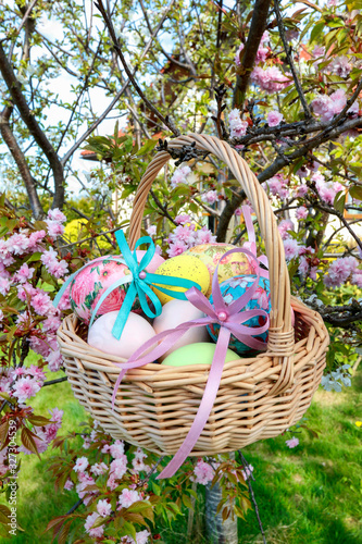 Wicker basket with Easter eggs in the garden.