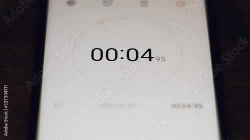 The stopwatch in the hands of a woman counts to 10 and the girl stops him