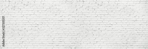 White Long Wide Wall Textured Background. Whitewashed Brick Facade Of Grungy Shabby Uneven Painted Plastered Wall. Whitened Brick Face Of Fence.