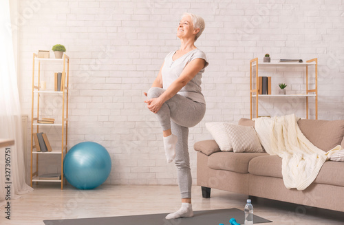 Stampa su Tela Active senior woman doing legs exercise at home