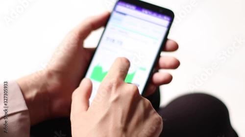 Young businesswoman watches financial statements of companies from the phone