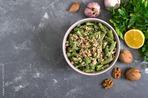 Salad with green beans and spicy walnut sauce in a bowl. Vegetarian, vegan menu. Top view.