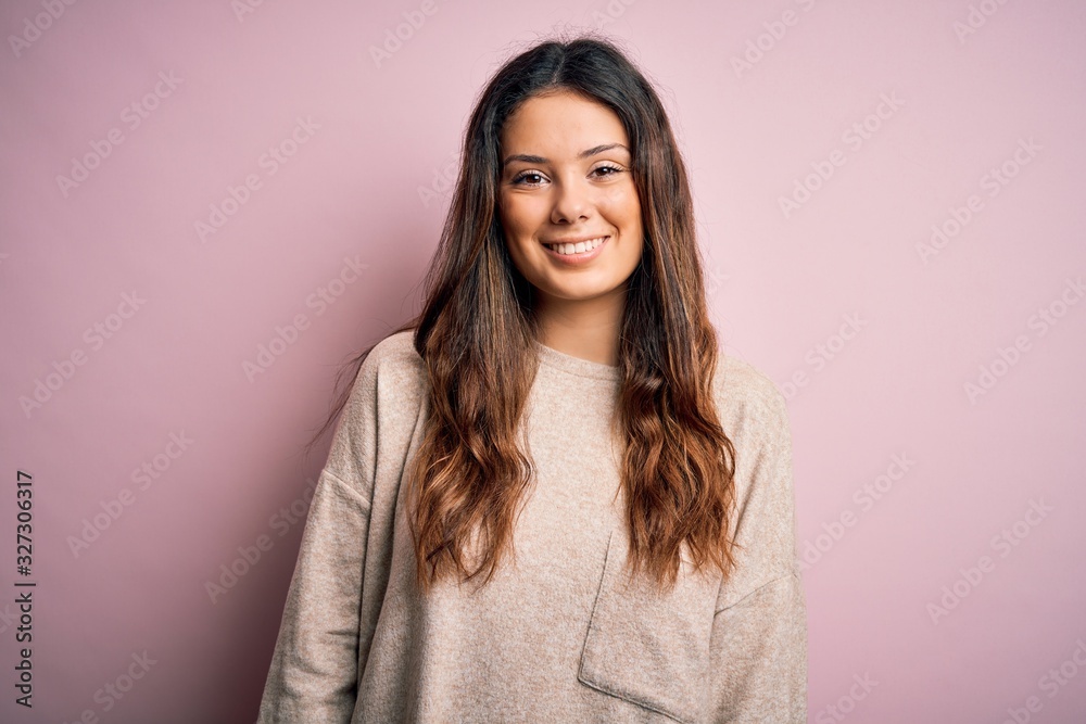 Young beautiful brunette woman wearing casual sweater standing over pink background with a happy and cool smile on face. Lucky person. Young beautiful brunette woman wearing casual sweater standing over pink background with a happy and cool smile on face. Lucky person.