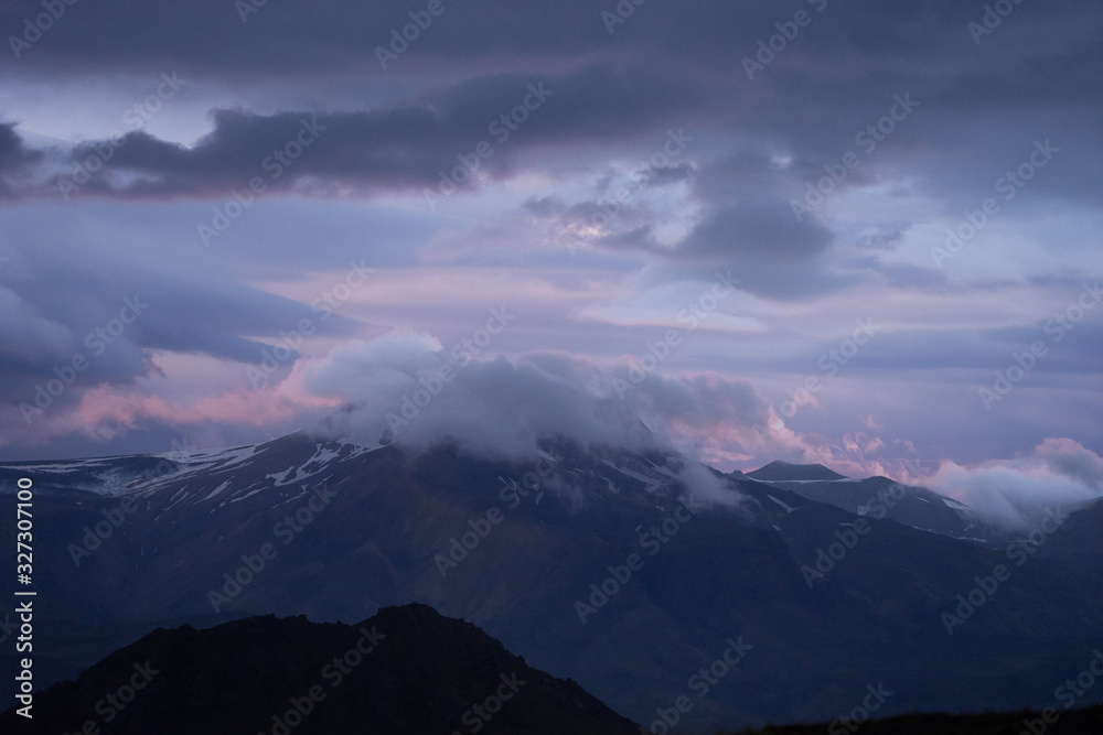 Mountain peak with snow and clouds during dramatic and colorful sunset on the laugavegur Hiking trail close to Thorsmork