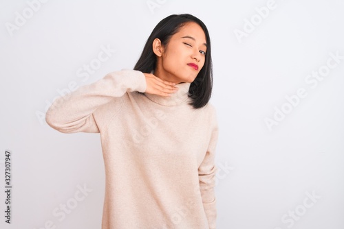 Young chinese woman wearing turtleneck sweater standing over isolated white background cutting throat with hand as knife, threaten aggression with furious violence © Krakenimages.com