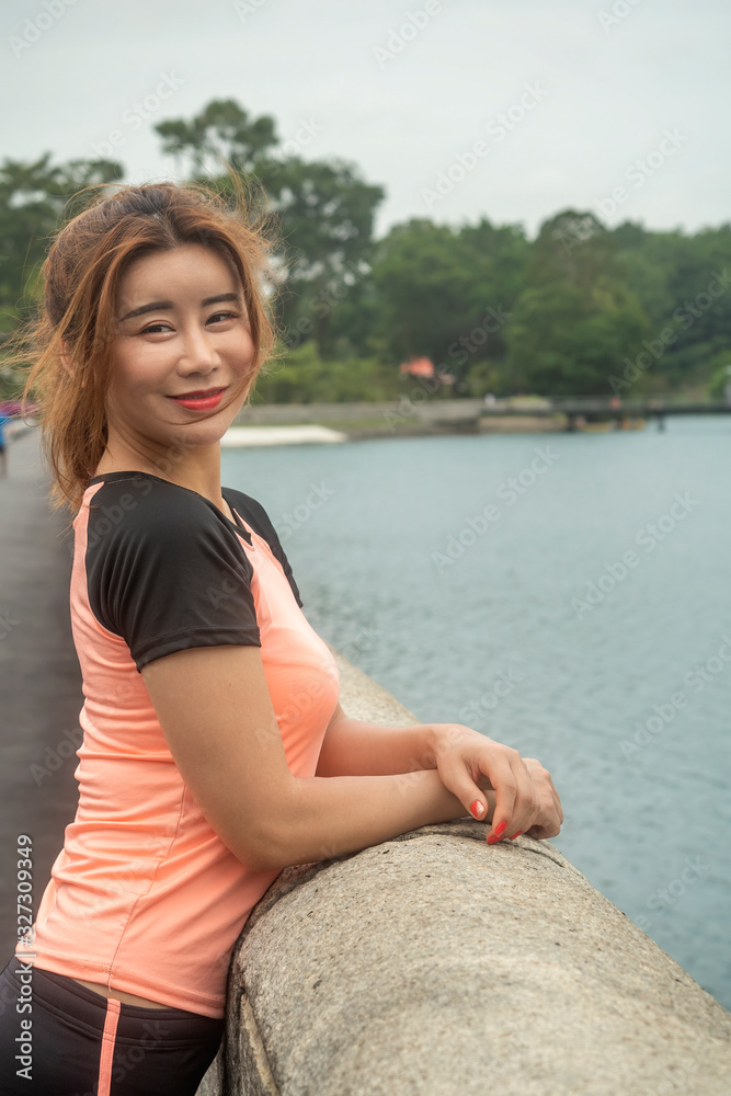 Asian Chinese girl in her sports outfit smiling and posing for camera after finishing morning workout session Asian Chinese girl in her sports outfit smiling and posing for camera after finishing morning workout session