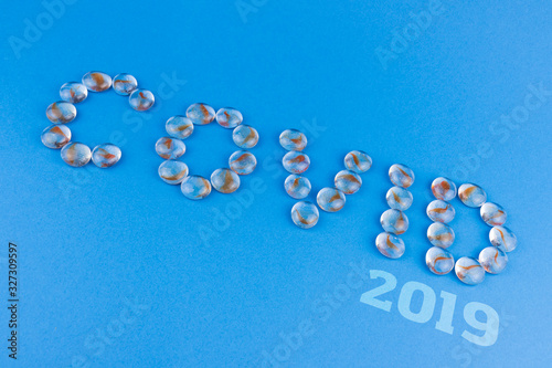 Name coronavirus covid 2019 made of transparent stones on a blue background. photo