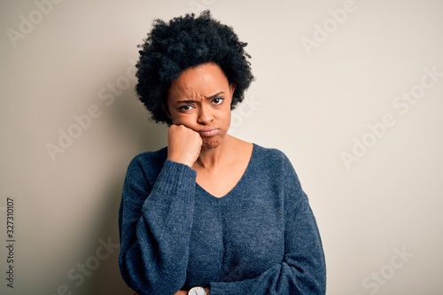 Young beautiful African American afro woman with curly hair wearing casual sweater thinking looking tired and bored with depression problems with crossed arms.