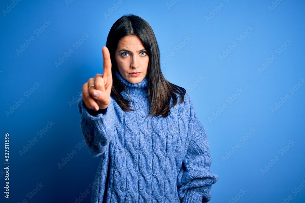 Young brunette woman with blue eyes wearing casual turtleneck sweater Pointing with finger up and angry expression, showing no gesture Young brunette woman with blue eyes wearing casual turtleneck sweater Pointing with finger up and angry expression, showing no gesture