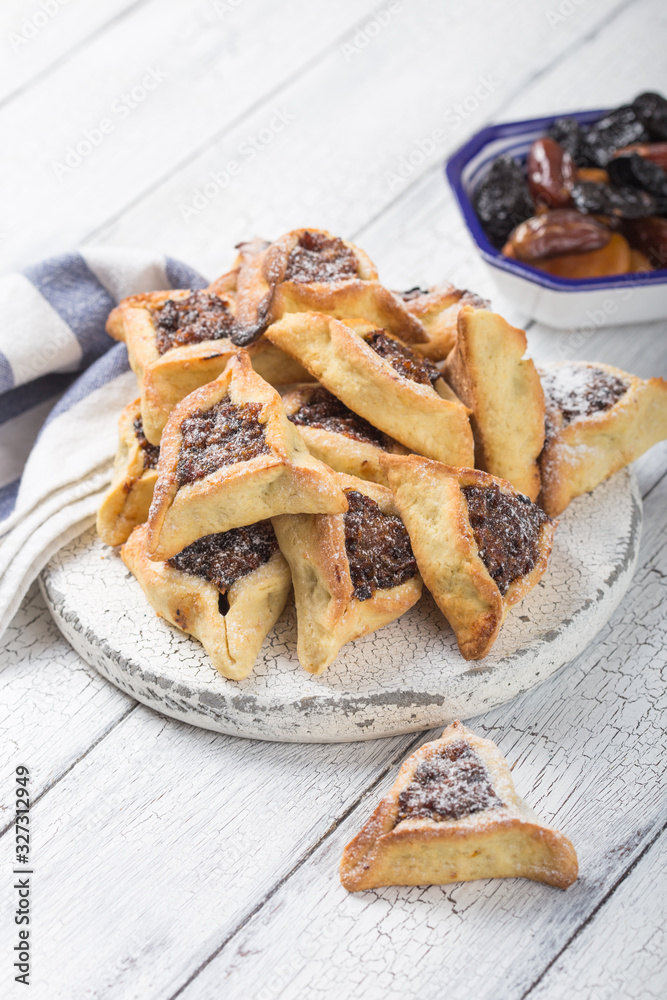 Traditional Jewish Hamantaschen cookies with dried apricots, dates. Purim celebration concept. Сarnival holiday background. Selective focus. Copy space. Traditional Jewish Hamantaschen cookies with dried apricots, dates. Purim celebration concept. Сarnival holiday background. Selective focus. Copy space.