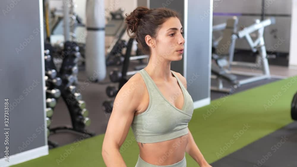 Woman working on her triceps and biceps in a gym with dumbbells Woman working on her triceps and biceps in a gym with dumbbells