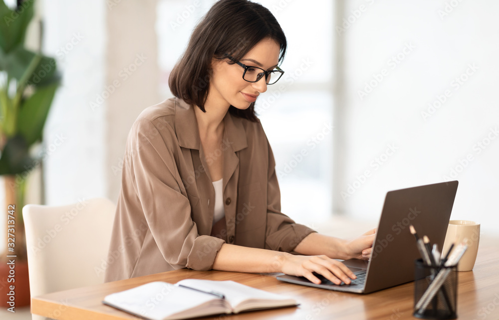 Beautiful girl working on her laptop at contemporary office Beautiful girl working on her laptop at contemporary office