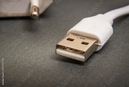 USB charger cable on dark surface closeup often used for charging smartphone or tablet