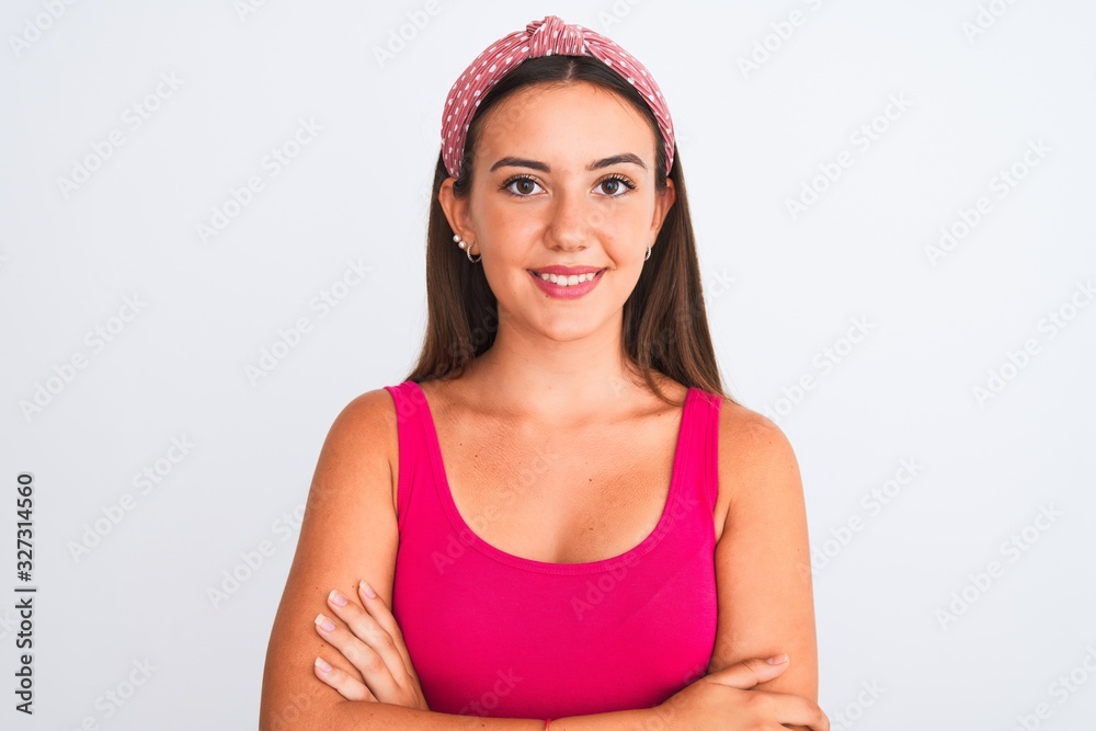 Young beautiful girl wearing pink casual t-shirt and diadem over isolated white background happy face smiling with crossed arms looking at the camera. Positive person. Young beautiful girl wearing pink casual t-shirt and diadem over isolated white background happy face smiling with crossed arms looking at the camera. Positive person.