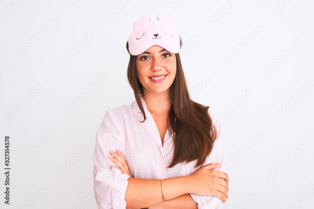 Young beautiful girl wearing pajama and sleep mask standing over isolated white background happy face smiling with crossed arms looking at the camera. Positive person. Young beautiful girl wearing pajama and sleep mask standing over isolated white background happy face smiling with crossed arms looking at the camera. Positive person.