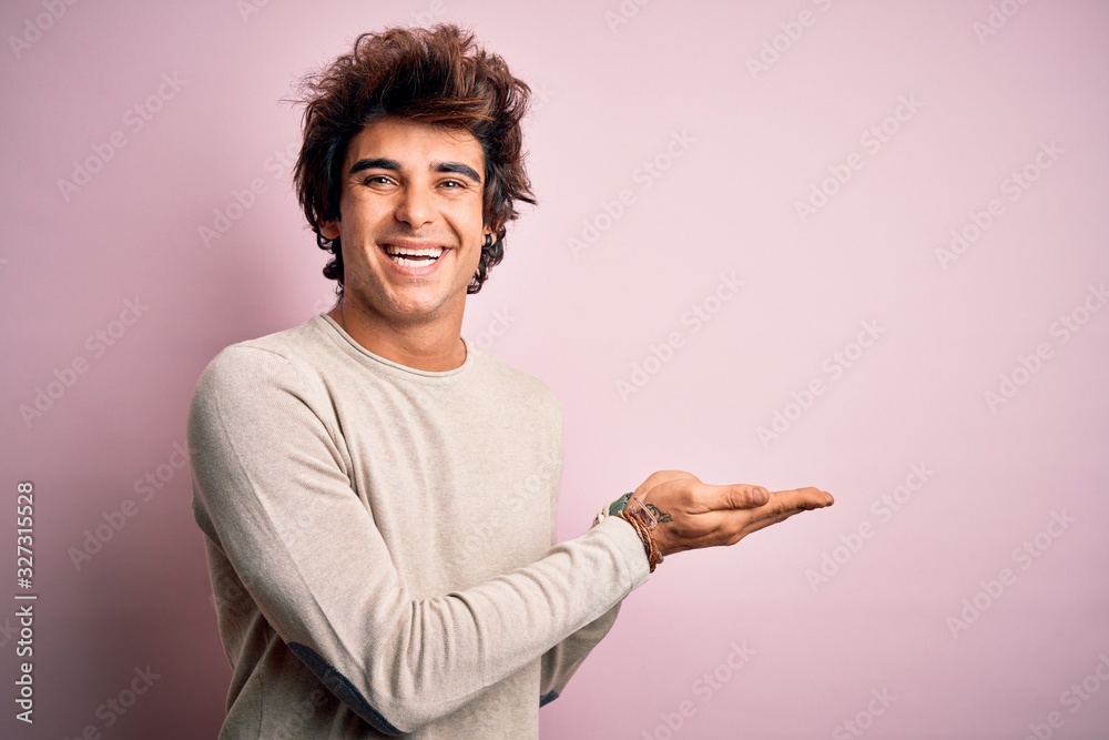 Young handsome man wearing casual t-shirt standing over isolated pink background pointing aside with hands open palms showing copy space, presenting advertisement smiling excited happy Young handsome man wearing casual t-shirt standing over isolated pink background pointing aside with hands open palms showing copy space, presenting advertisement smiling excited happy
