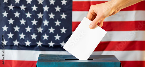 usa elections the hand of woman putting her vote in the ballot box