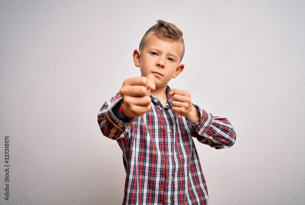 Naklejka premium Young little caucasian kid with blue eyes wearing elegant shirt standing over isolated background Punching fist to fight, aggressive and angry attack, threat and violence