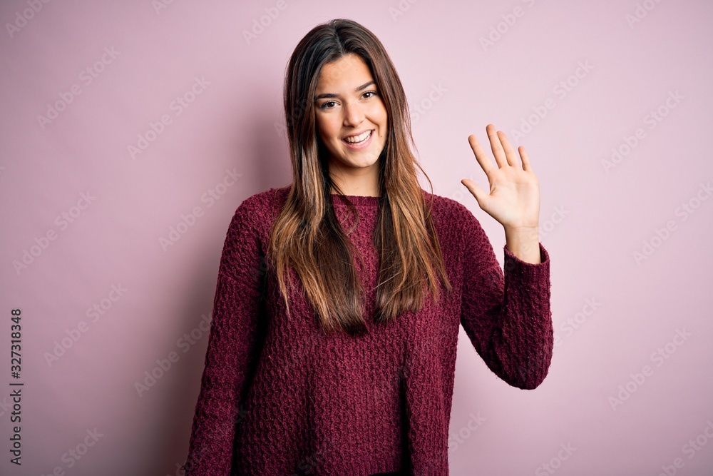 Young beautiful girl wearing casual sweater over isolated pink background showing and pointing up with fingers number five while smiling confident and happy. Young beautiful girl wearing casual sweater over isolated pink background showing and pointing up with fingers number five while smiling confident and happy.