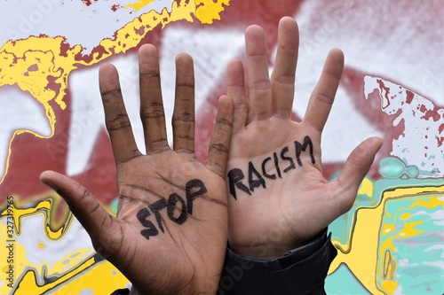 Photomontage of the hands of two men of different ethnicity in which the motto "stop racism" is written, with a multicolored background. Stop racism campaign