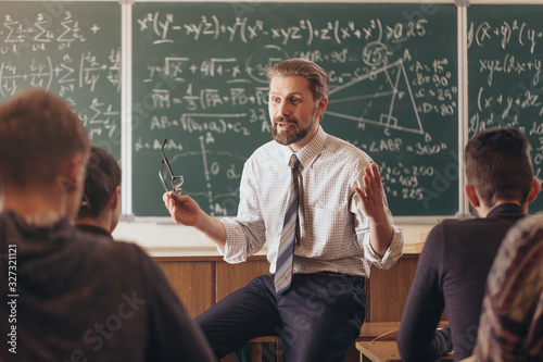Enthusiastic math teacher holding a lesson for high school students