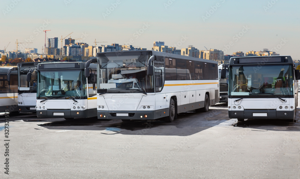 Buses in a parking lot amid the cityscape