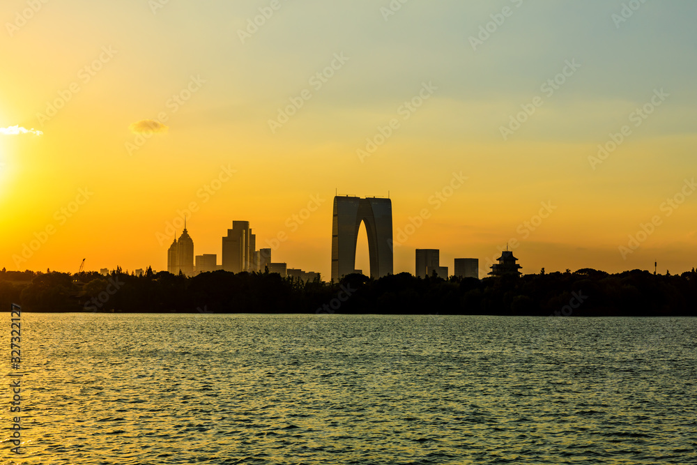 Beautiful city skyline and buildings with lake at sunset in Suzhou.