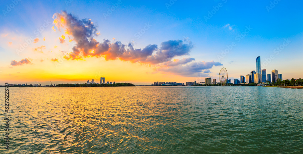 Beautiful city skyline and buildings with lake at sunset in Suzhou,panoramic view.