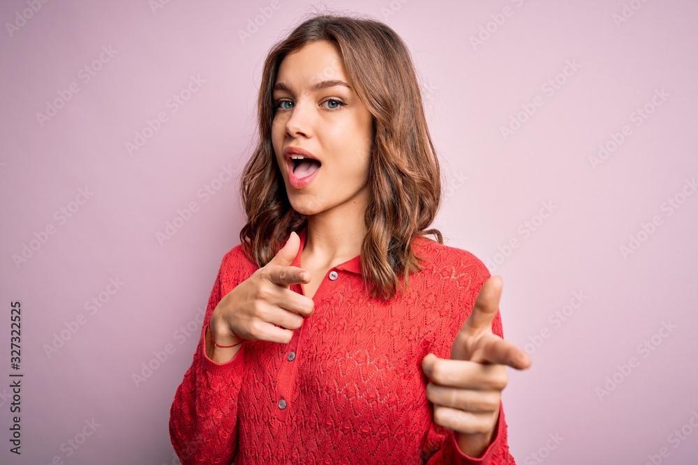 Young beautiful blonde casual girl over pink isolated background pointing fingers to camera with happy and funny face. Good energy and vibes. Young beautiful blonde casual girl over pink isolated background pointing fingers to camera with happy and funny face. Good energy and vibes.
