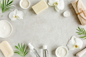 Foto auf Acrylglas Massagesalon Spa-Hautpflegekonzept. Natürliche/organische Spa-Kosmetikprodukte, Meersalz und tropische Palmblätter auf grauem Marmortisch von oben. Spa-Hintergrund mit Platz für einen Text, flache Lage, Draufsicht.  © K.Decor